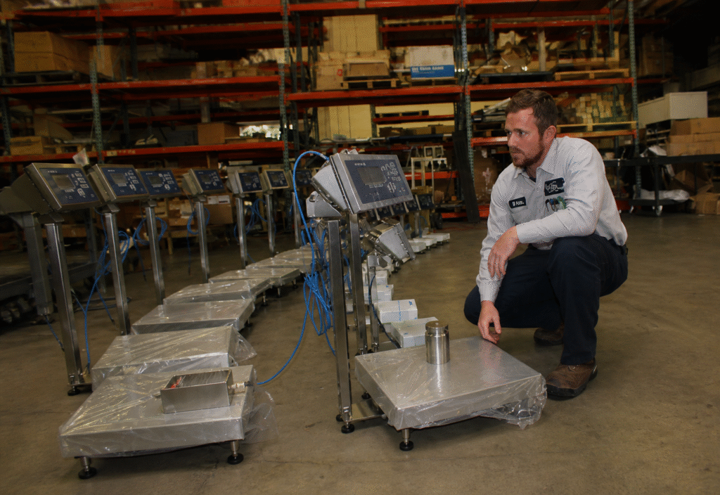 Engineer inspecting industrial weighing scales for Annual Maintenance Contract in UAE